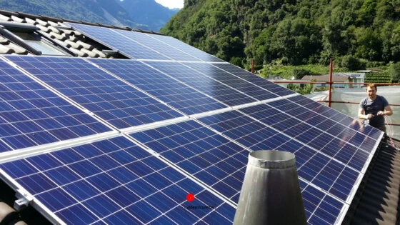 Pannelli solari installati su tetto in tegole con sfondo montano e tecnico al lavoro