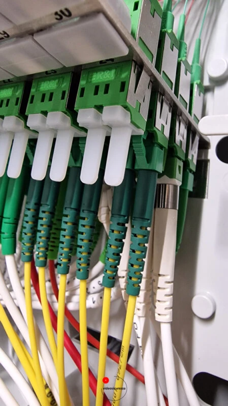 Dettaglio di cavi in fibra ottica SC/APC collegati a pannello di terminazione all’interno di un armadio di rete strutturato